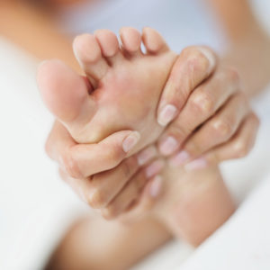 Woman pressuring foot with hands